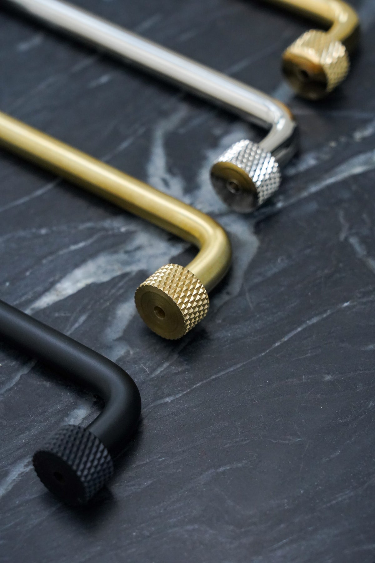 Kitchen handle in solid brass without lacquer. The handle has round feet with a knurled diamond-cut pattern that matches Quooker taps.