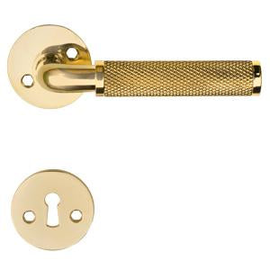 Funkis Nox door handle in polished brass with diamond-cut pattern, rose and keyhole escutcheon