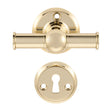 Rungsted cross-style door handle in polished brass, with rose and keyhole escutcheon