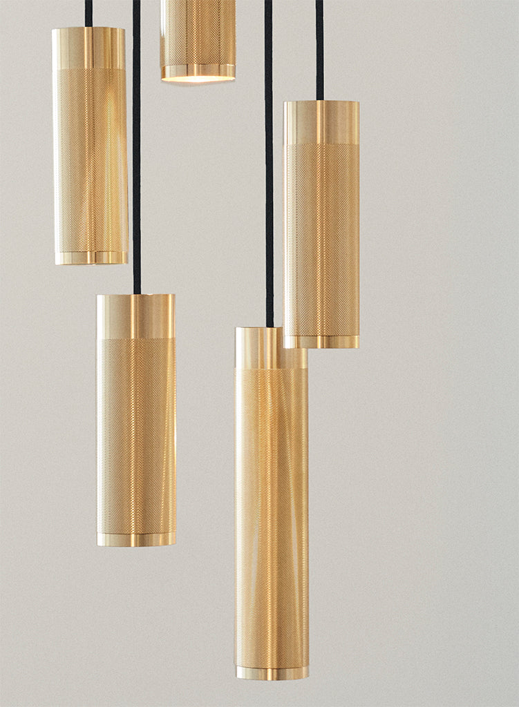 Nærbillede af lofthængt lampe med fem pendler i massiv messing med diamant slebet mønster og sorte stofledninger 