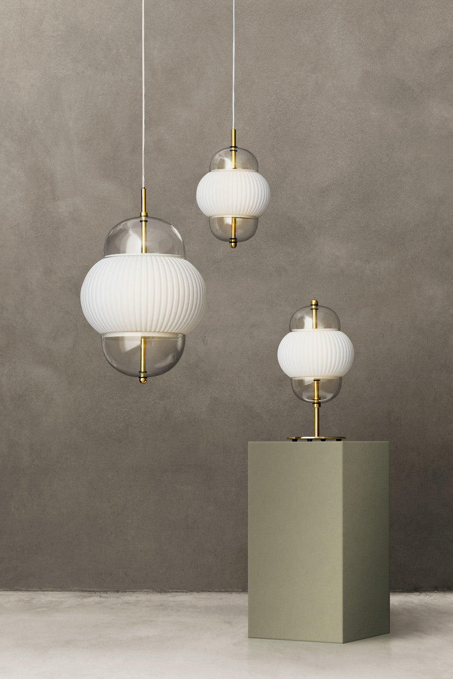 Lampe i klart glas og mat hvidt plisseret glas. Derudover har lampen detaljer i messing og en hvid stofledning. 
