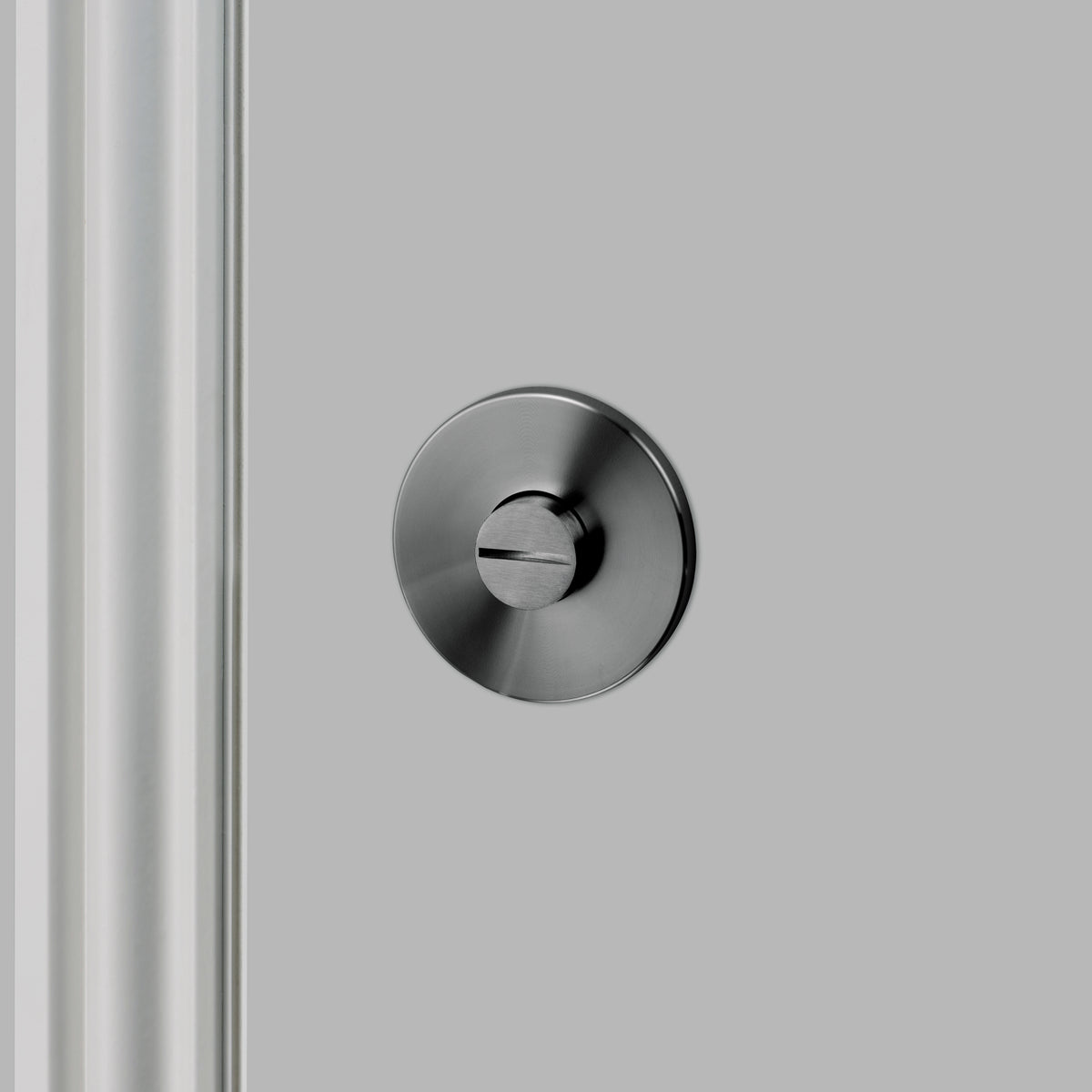 Gun metal vridelås i eksklusivt design med linjeret mønster. Her ses bagsiden af vridelåsen.